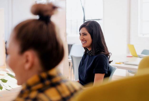 deux femmes souriantes dans un bureau